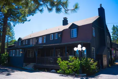 a large black house with a tree in front of it at Sessions Retreat & Hotel in Big Bear Lake