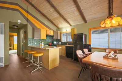 a kitchen with a wooden ceiling and a table and chairs at Sessions Retreat & Hotel in Big Bear Lake