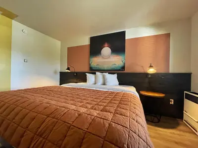 a hotel room with a bed and a painting on the wall at Sessions Retreat & Hotel in Big Bear Lake