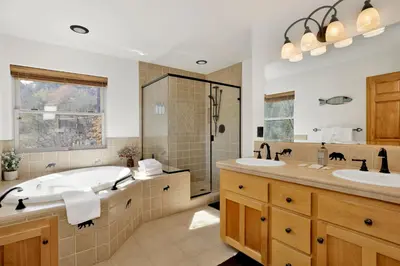 a bathroom with two sinks and a tub and a shower at View On the Rocks Scenic Mountain Oasis with Hot Tub, Fire Pit and Game Room in Big Bear Lake