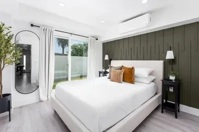 a bedroom with a white bed and a large window at Cozy LA Getaway Fast Wi-Fi and Smart TV in Los Angeles