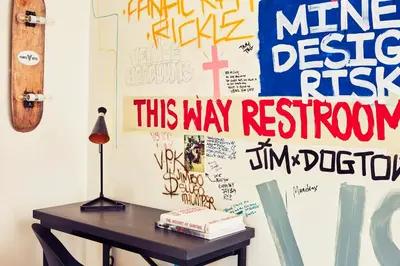 a table with a lamp and a wall covered in graffiti at Venice V Hotel in Los Angeles