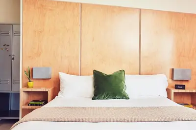 a bedroom with a bed with a green pillow on it at Venice V Hotel in Los Angeles