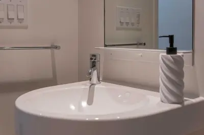 a white sink in a bathroom with a mirror at The W Hotel Residence With Roof Top Pool, Gym Plus 2 Free Valet Parking spaces in Los Angeles
