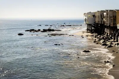 a beach with a group of buildings and the ocean at Malibu Breeze in Malibu Beach