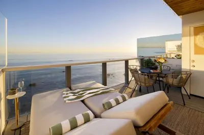 a balcony with a couch and a table at Malibu Breeze in Malibu Beach