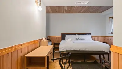 a bedroom with a bed and a table and a chair at 5BDR Hot Tub Deck Firepit Mins to Village Lake The Hilltop by AvantStay in Lake Arrowhead