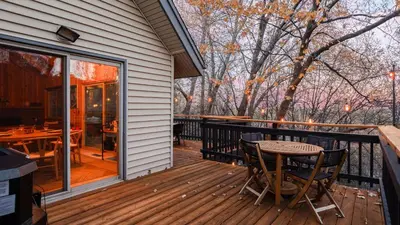 a porch with a table and chairs on a deck at 5BDR Hot Tub Deck Firepit Mins to Village Lake The Hilltop by AvantStay in Lake Arrowhead