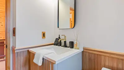 a bathroom with a white sink and a mirror at 5BDR Hot Tub Deck Firepit Mins to Village Lake The Hilltop by AvantStay in Lake Arrowhead
