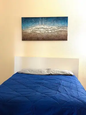a blue bed with a painting on the wall at Downtown LA Urban Escape in Los Angeles