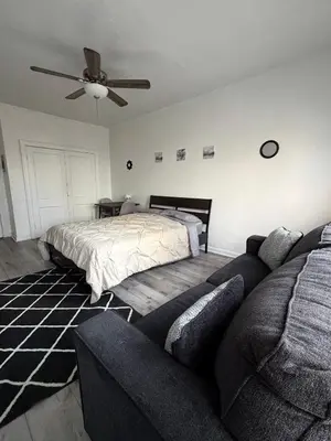 a bedroom with a bed and a couch and a ceiling fan at Westlake MacArthur Park Studio in Los Angeles