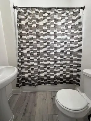 a bathroom with a toilet and a shower curtain at Westlake MacArthur Park Studio in Los Angeles