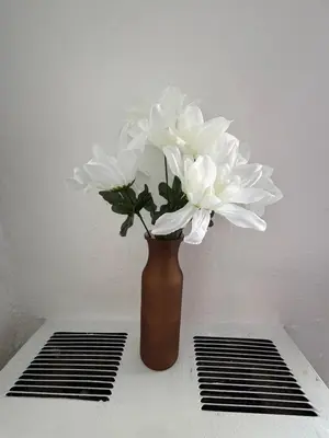a vase filled with white flowers sitting on a table at Westlake MacArthur Park Studio in Los Angeles