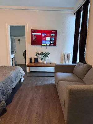 a living room with a couch and a tv at Wilshire Center K-Town Studio in Los Angeles