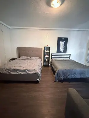 a bedroom with two beds and a dresser in it at Wilshire Center K-Town Studio in Los Angeles