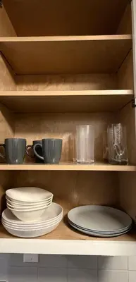 a shelf with plates and cups and bowls in a kitchen at Steps from The Hollywood Walk of Fame in Los Angeles