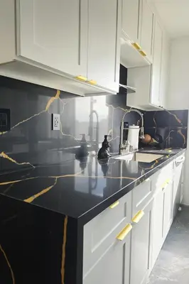 a kitchen with white cabinets and a black counter top at Kenmore relax in Los Angeles