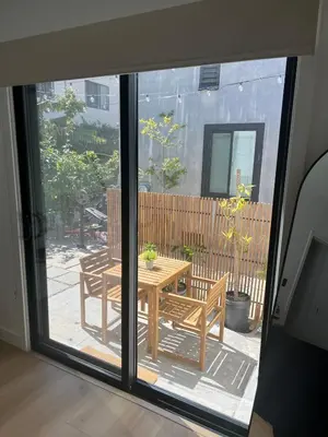 a sliding glass door with a table and bench outside at East Hollywood Modern Spacious Bungalow in Los Angeles