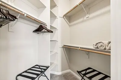 a walk in closet with white walls and wooden shelves at Chic Marina Oasis 5 star Amenities Central in Los Angeles