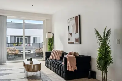 a living room with a black couch and a table at Modern Marina Sanctuary Central Pool Gym Spa in Los Angeles
