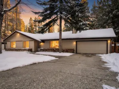a house with a garage in the snow at Skiers Crest - Hot Tub, Yard, Near Lake & Slopes in Big Bear Lake