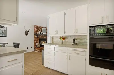 a kitchen with white cabinets and a stove top oven at Skiers Crest - Hot Tub, Yard, Near Lake & Slopes in Big Bear Lake