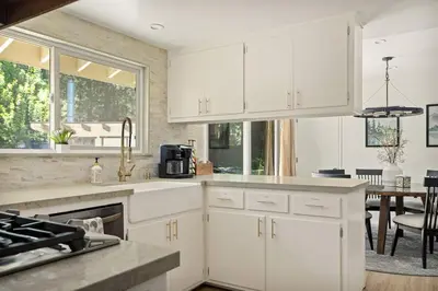 a kitchen with white cabinets and a dining room at Skiers Crest - Hot Tub, Yard, Near Lake & Slopes in Big Bear Lake