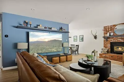 a living room with a couch and a large window at Skiers Crest - Hot Tub, Yard, Near Lake & Slopes in Big Bear Lake