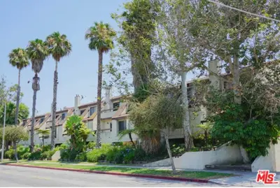 a building with palm trees in front of a street at 2 Bed Apartment with Private Terrace Near SoFi in Los Angeles