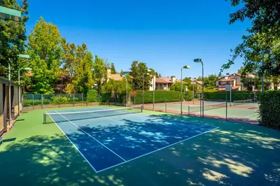 a tennis court with a net on it at Elsa House in Warner Center Plaza One Heliport