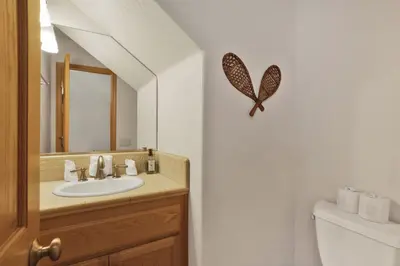 a bathroom with a sink and a butterfly on the wall at Brownie Resort Your Walk-to-Summit Getaway Family's Snowboarders Skiers in Big Bear Lake