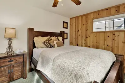 a bedroom with a bed and a wooden wall at Brownie Resort Your Walk-to-Summit Getaway Family's Snowboarders Skiers in Big Bear Lake