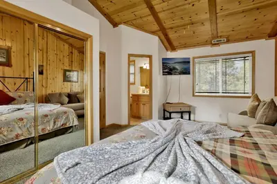 a bedroom with a bed and a living room at Brownie Retreat Walk-to-Summit Mountain Getaway for Snowboarders & Skiers in Big Bear Lake