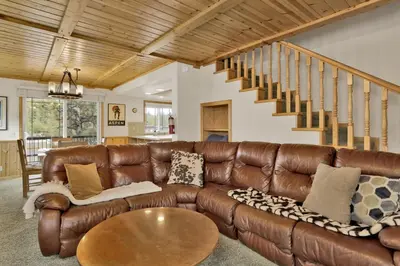 a living room with a brown leather couch and a table at Brownie Resort Retreat Walk-to-Ski Snow Summit Duplex Getaway in Big Bear Lake