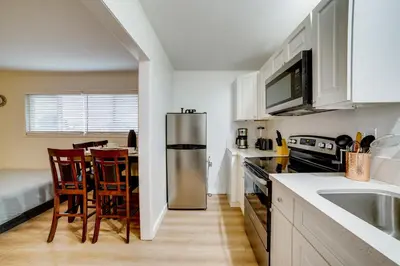 a kitchen with a stainless steel refrigerator and a table at Work and Play! Studio 7 Mi to Dtwn San Bernardino in Rialto