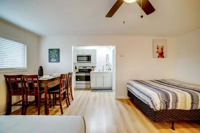 a bedroom with a bed and a table and a kitchen at Work and Play! Studio 7 Mi to Dtwn San Bernardino in Rialto