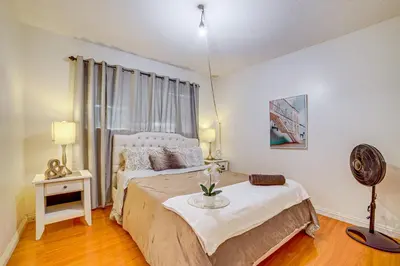 a bedroom with a bed and a table with flowers on it at Home 1 Mi to UC Riverside Families Welcome! in Riverside