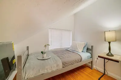 a bedroom with a bed with a table and a window at Home 1 Mi to UC Riverside Families Welcome! in Riverside