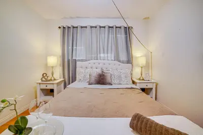 a bedroom with a large bed with two tables and two lamps at Home 1 Mi to UC Riverside Families Welcome! in Riverside