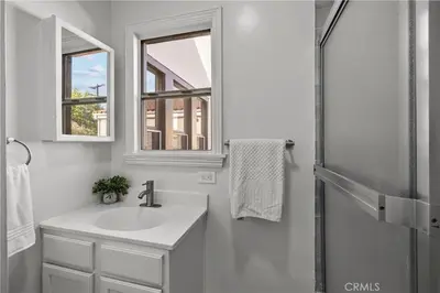 a white bathroom with a sink and a mirror at Fully Furnished 1-Bedroom in Los Angeles