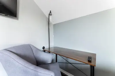 a room with a chair and a table and a television at Hawthorne Haven Spacious 4BR Retreat in Hawthorne