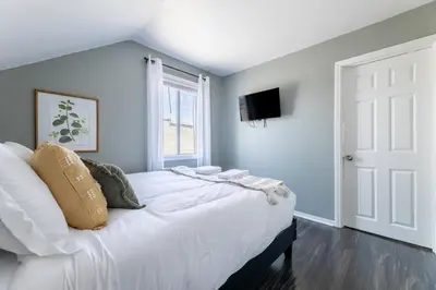a bedroom with a large white bed and a window at Hawthorne Haven Spacious 4BR Retreat in Hawthorne