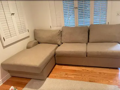 a brown couch in a living room with a window at Cozy Home in Picturesque LA Near Major Attractions