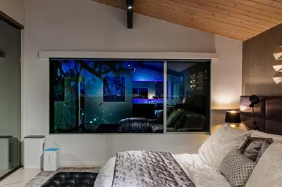 a bedroom with a large window in the wall at Hillside Luxury MidCentury Modern Spa Retreat View in Los Angeles