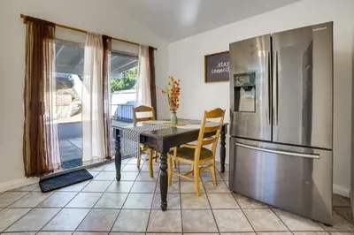 a kitchen with a table and a refrigerator at Home 8 Mi to Dtwn Riverside Families Welcome! in Moreno Valley
