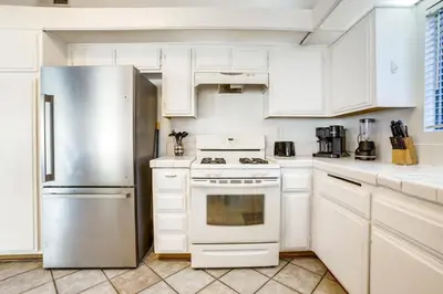 a kitchen with white cabinets and a stainless steel refrigerator at Home 8 Mi to Dtwn Riverside Families Welcome! in Moreno Valley