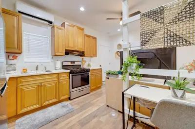a kitchen with wooden cabinets and a stove top oven at Work and Play! Studio Retreat 2 Mi to Dtwn Riverside in Riverside