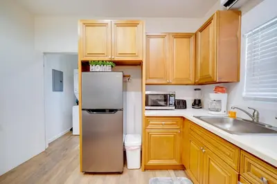 a kitchen with wooden cabinets and a refrigerator at Work and Play! Studio Retreat 2 Mi to Dtwn Riverside in Riverside