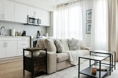 a white living room with a couch and two tables at Beautiful 1BR with City Views in Los Angeles