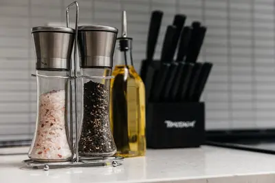 a counter with two pepper grinders and a bottle at Beautiful 1BR with City Views in Los Angeles